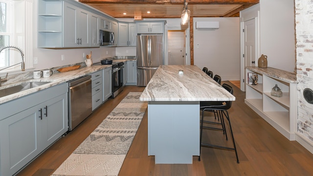 20 N High St, Bridgton, ME 04009 - kitchen with appliances with stainless steel finishes, wood ceiling, an AC wall unit, a kitchen island, and a breakfast bar area