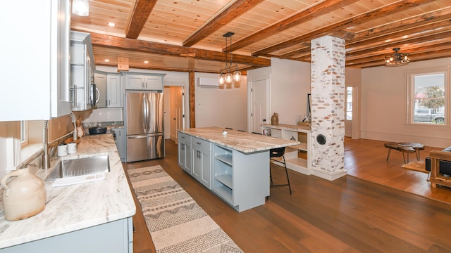 20 N High St, Bridgton, ME 04009 - kitchen with stainless steel refrigerator, light stone countertops, beamed ceiling, decorative light fixtures, and a kitchen island