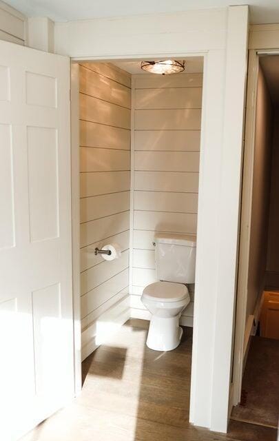 20 N High St, Bridgton, ME 04009 - bathroom featuring wood-type flooring, toilet, and wooden walls