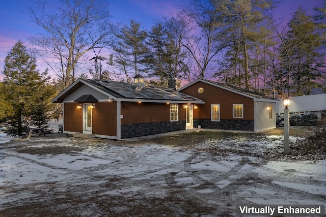 ranch-style home featuring solar panels