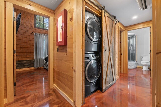 18 Severin Way, Limerick, ME 04048 - laundry room featuring stacked washer / dryer and a barn door