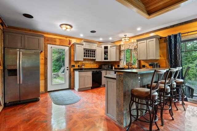 18 Severin Way, Limerick, ME 04048 - kitchen featuring stainless steel fridge with ice dispenser, a peninsula, a kitchen breakfast bar, dark countertops, and concrete flooring