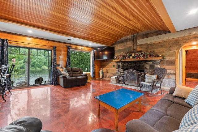 18 Severin Way, Limerick, ME 04048 - living room featuring vaulted ceiling, concrete floors, wooden walls, arched walkways, and a fireplace