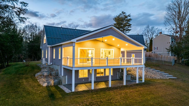 back of house with a deck and a yard