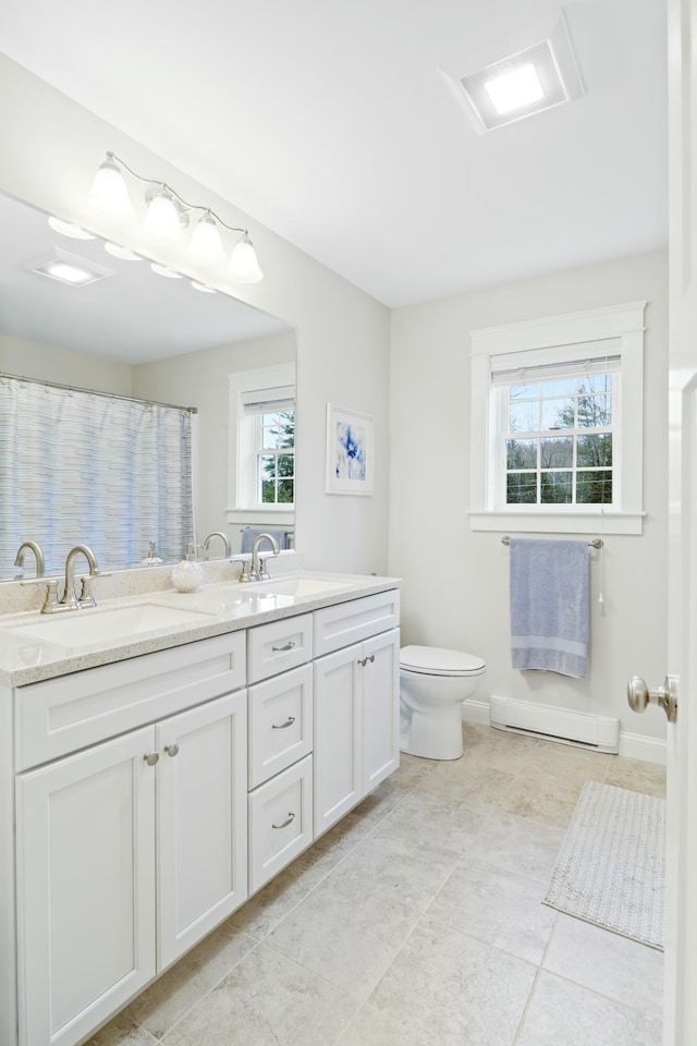 bathroom featuring toilet, a wealth of natural light, vanity, and a baseboard heating unit