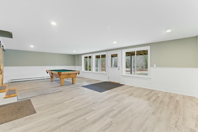 recreation room featuring a baseboard radiator, pool table, a barn door, and light hardwood / wood-style flooring