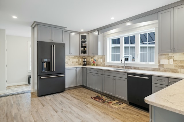 kitchen featuring sink, dishwasher, light stone countertops, gray cabinets, and high end refrigerator