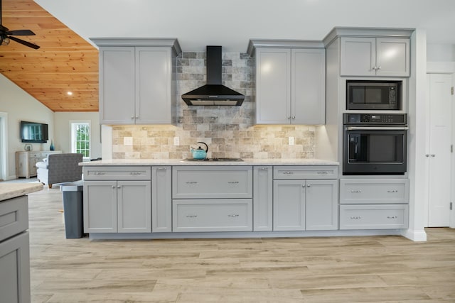 kitchen featuring wall chimney range hood, built in microwave, oven, gray cabinetry, and wooden ceiling