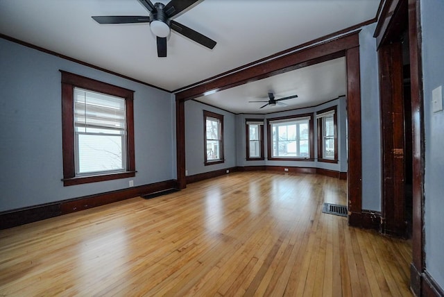 empty room with crown molding, light hardwood / wood-style flooring, and ceiling fan