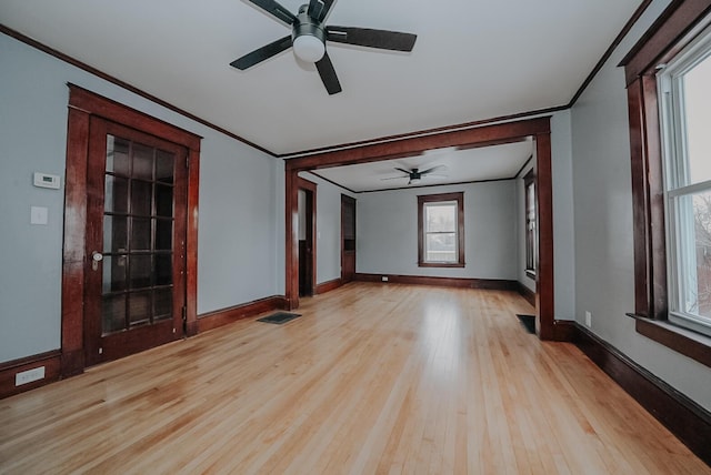 empty room with ceiling fan, light wood-type flooring, and ornamental molding