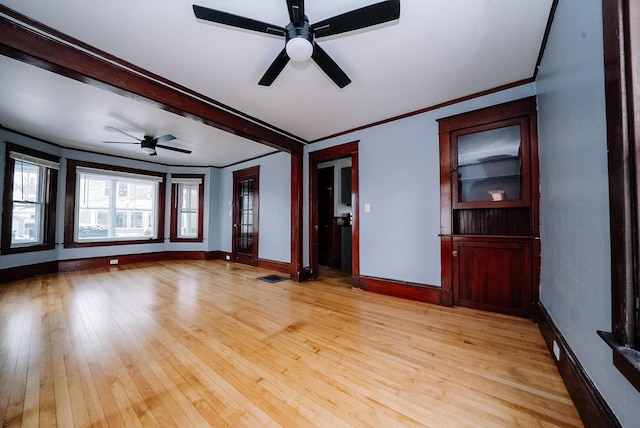 empty room featuring ceiling fan, light wood-type flooring, and ornamental molding