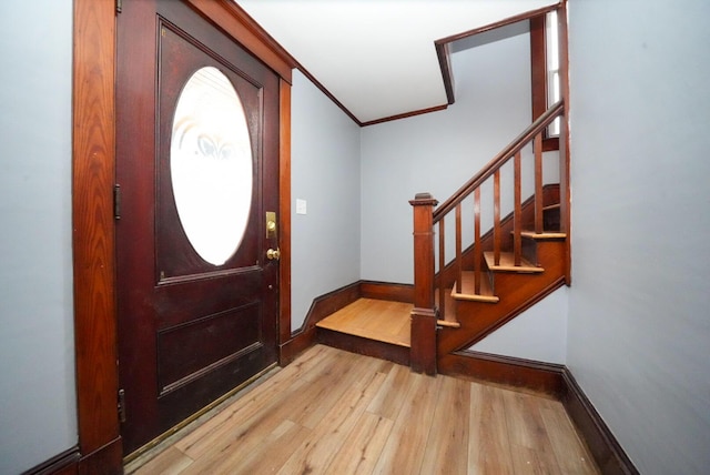 entrance foyer with light hardwood / wood-style floors and ornamental molding