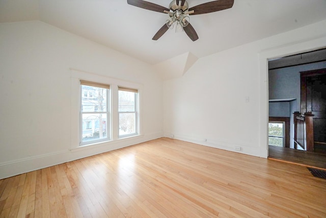 spare room featuring light hardwood / wood-style flooring, a wealth of natural light, lofted ceiling, and ceiling fan