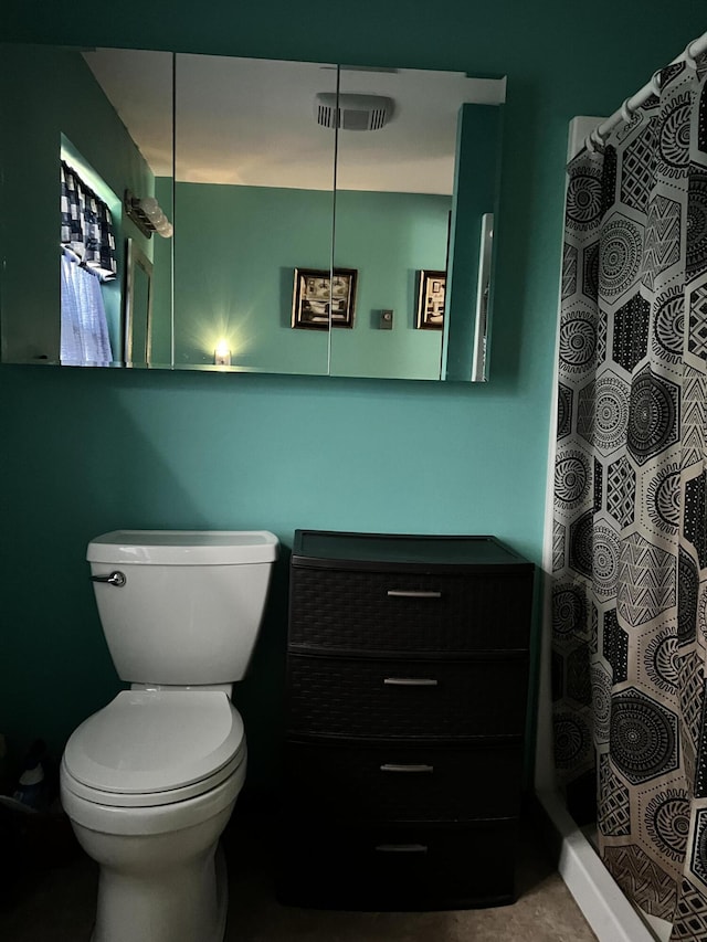 bathroom featuring curtained shower and toilet