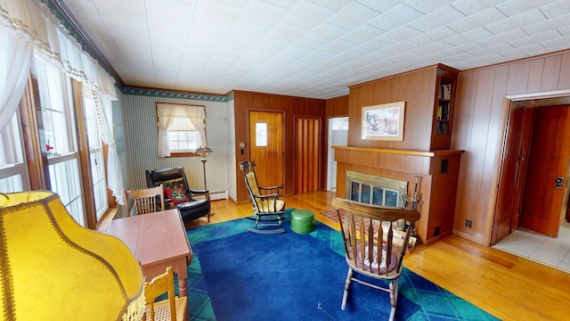 90 E Ter, Millinocket, ME 04462 - sitting room featuring wood finished floors, crown molding, a glass covered fireplace, wooden walls, and a baseboard radiator