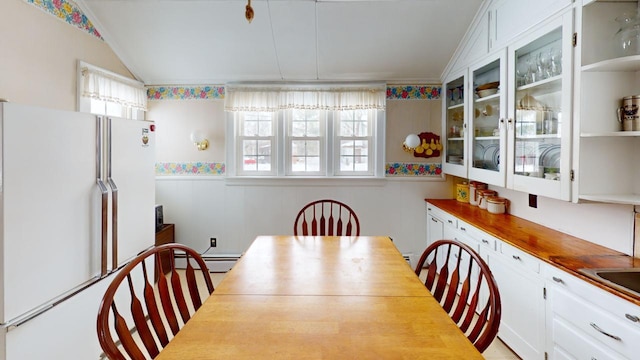 90 E Ter, Millinocket, ME 04462 - dining area featuring a baseboard radiator, a wainscoted wall, and vaulted ceiling