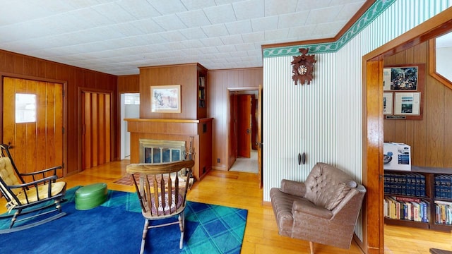 90 E Ter, Millinocket, ME 04462 - living area featuring crown molding, a glass covered fireplace, wood finished floors, and wooden walls