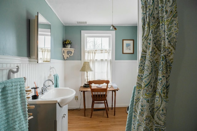 interior space featuring sink, light hardwood / wood-style floors, plenty of natural light, and ornamental molding