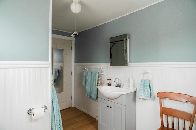 bathroom with vanity, wood-type flooring, and ornamental molding