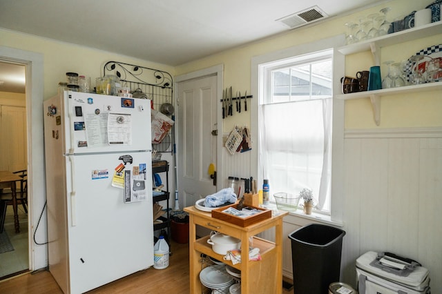 kitchen featuring white fridge and hardwood / wood-style flooring