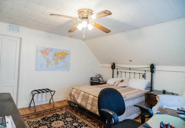 bedroom featuring ceiling fan, wood-type flooring, and vaulted ceiling