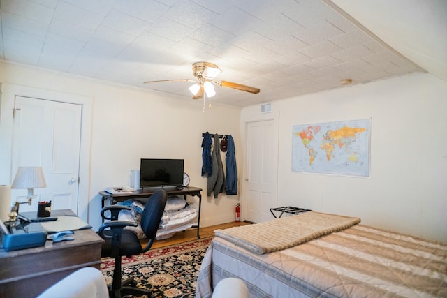 bedroom featuring wood-type flooring, ceiling fan, and crown molding