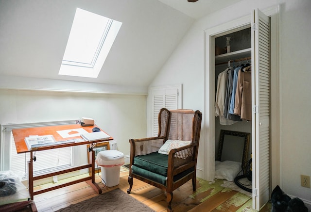 sitting room with wood-type flooring and lofted ceiling with skylight