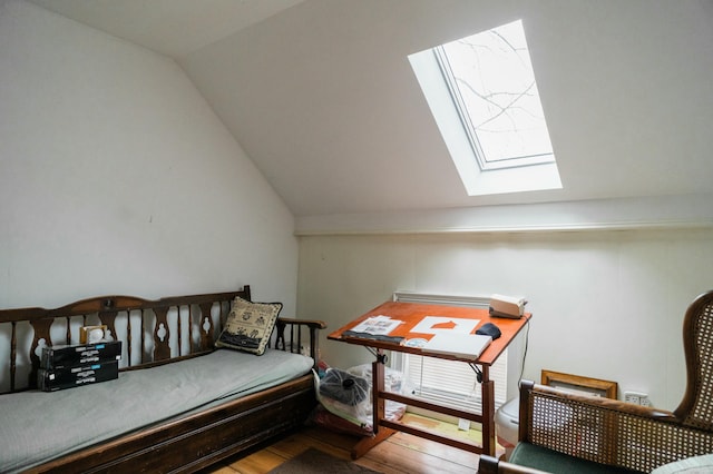 interior space featuring lofted ceiling with skylight and hardwood / wood-style flooring