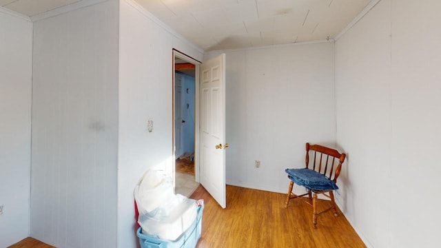 living area with crown molding and hardwood / wood-style floors