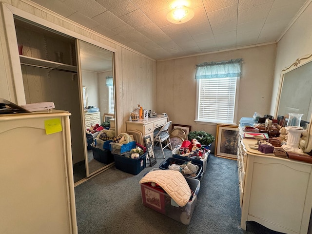 bedroom with crown molding, a closet, and dark colored carpet