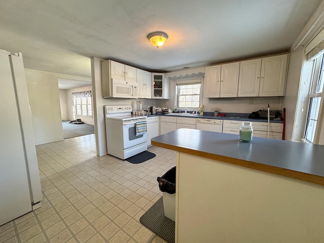 kitchen with white cabinets, white appliances, and sink