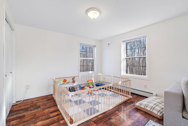 bedroom with baseboard heating and dark hardwood / wood-style floors