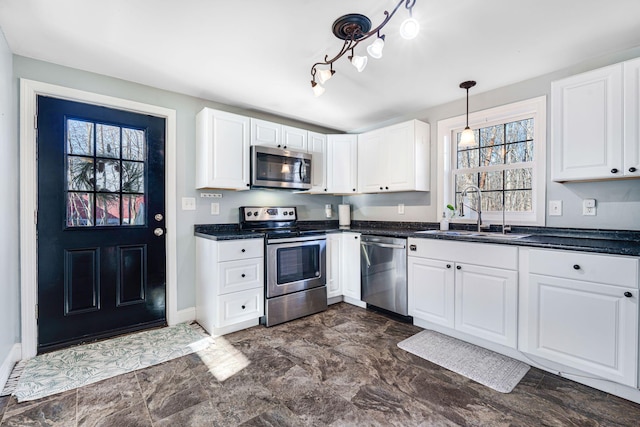 kitchen with pendant lighting, sink, white cabinetry, and stainless steel appliances