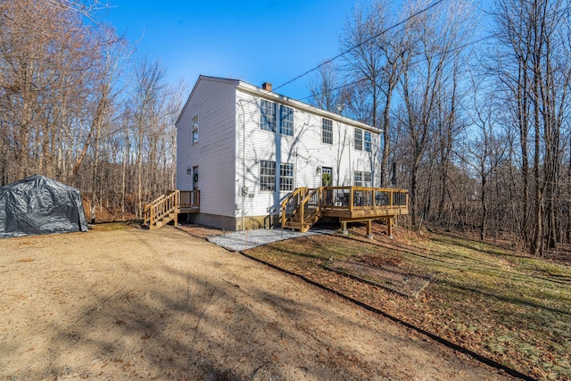 rear view of house with a deck and a yard