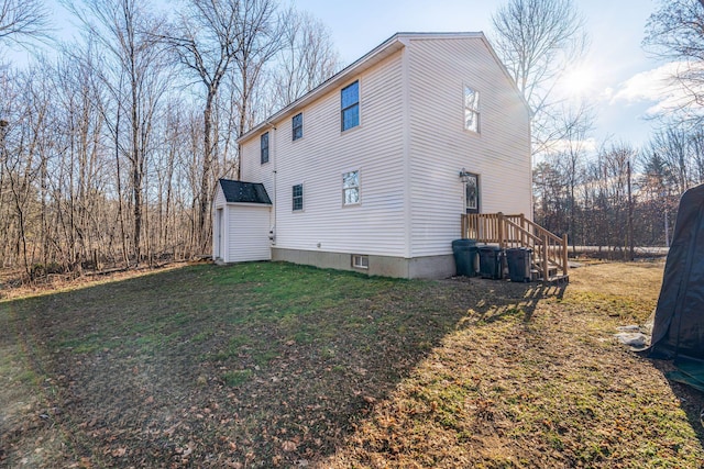 view of home's exterior with a storage unit and a yard