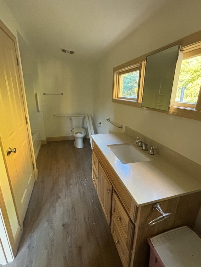 bathroom featuring wood-type flooring, vanity, and toilet