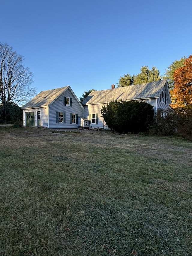 rear view of property featuring a lawn