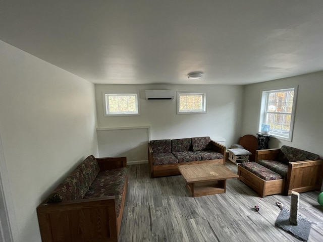 living room with hardwood / wood-style flooring, an AC wall unit, and a wealth of natural light