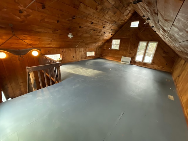 additional living space featuring concrete flooring, vaulted ceiling, wooden walls, and wood ceiling