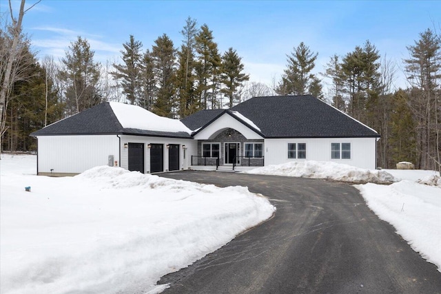 ranch-style house featuring a garage and aphalt driveway