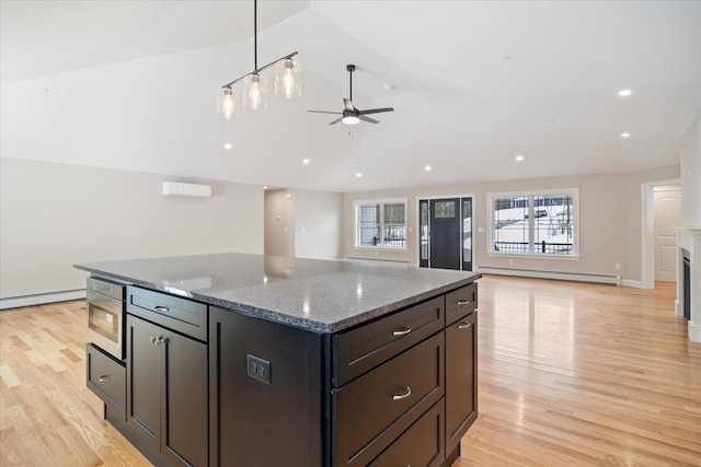 kitchen with light wood-type flooring, a baseboard radiator, a center island, and lofted ceiling