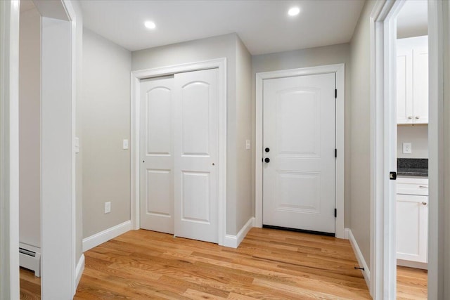 interior space featuring light wood-style floors, baseboards, baseboard heating, and recessed lighting