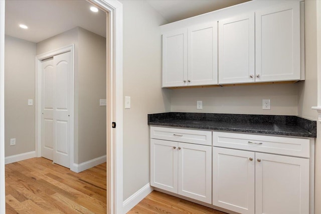 kitchen with baseboards, recessed lighting, light wood-type flooring, and white cabinets