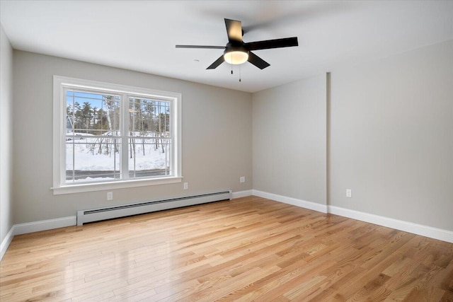 empty room with a baseboard heating unit, light wood-style flooring, and baseboards