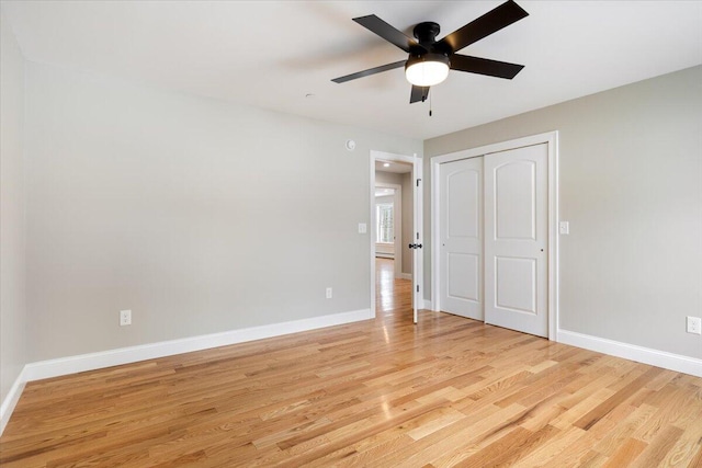 unfurnished bedroom featuring light wood-type flooring, ceiling fan, baseboards, and a closet