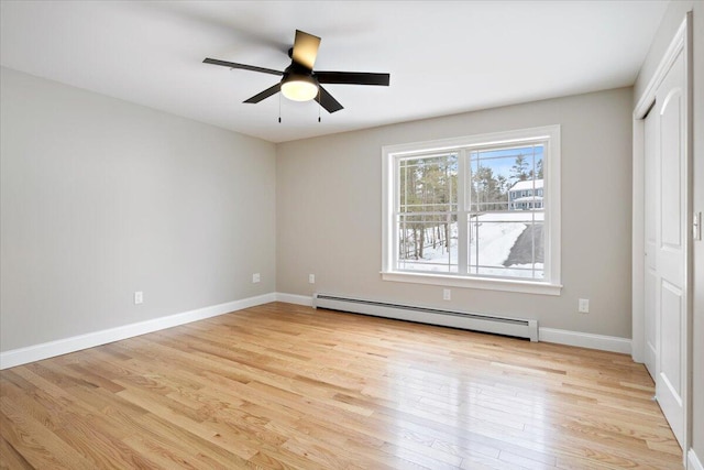 unfurnished room featuring light wood-style flooring, baseboards, baseboard heating, and a ceiling fan