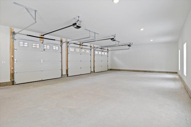 garage featuring a garage door opener, recessed lighting, and baseboards