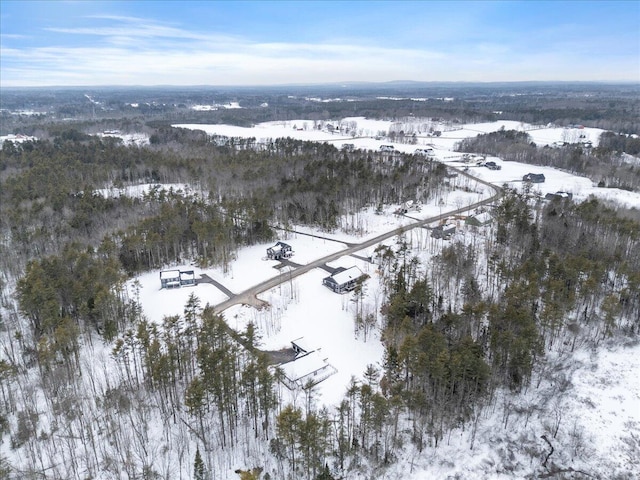 snowy aerial view featuring a wooded view