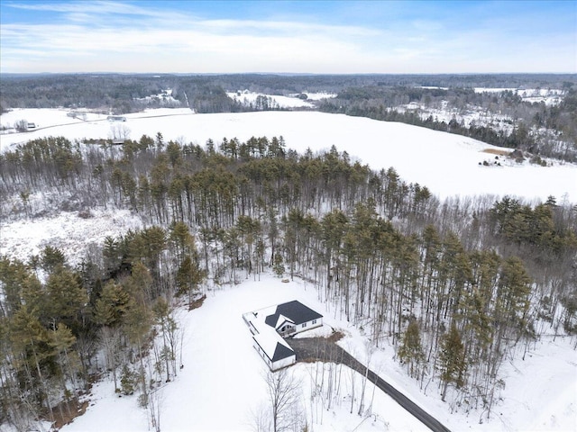 snowy aerial view with a wooded view