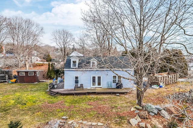 rear view of house featuring a yard, a deck, and a storage shed